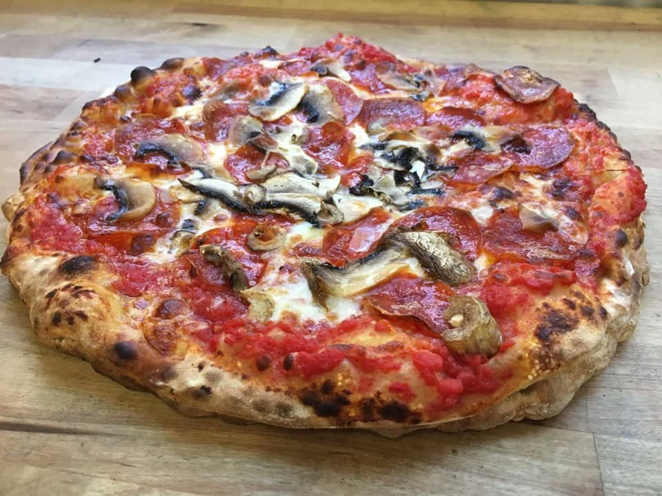 Freshly baked wood-fired pizza with pepperoni and mushrooms from Pies on Wheels
